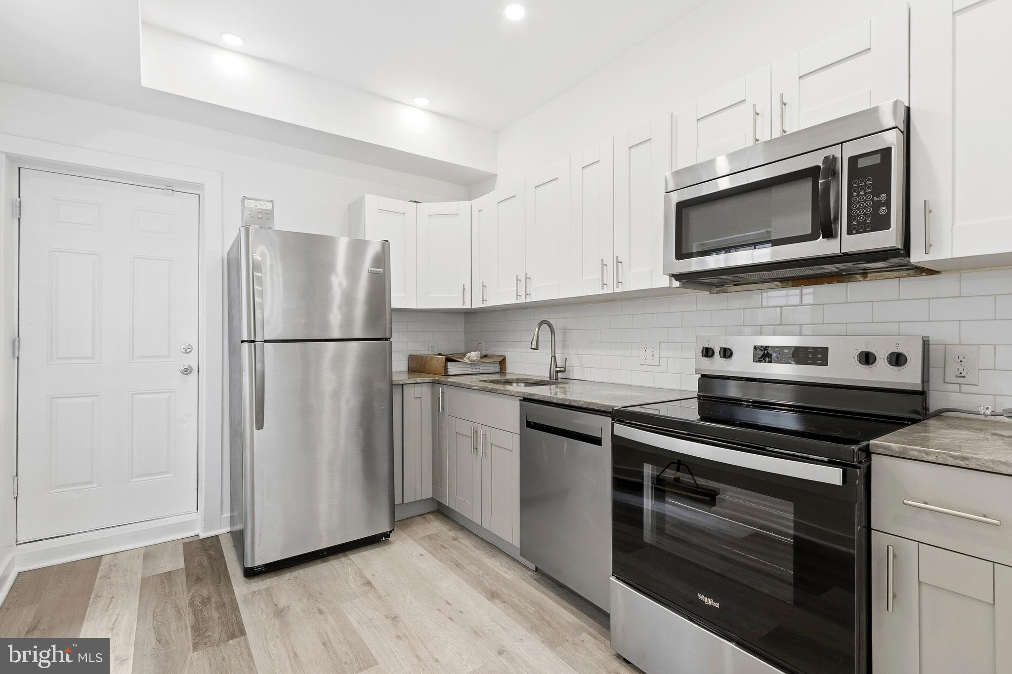 2150 North Franklin Street Philadelphia, PA 19122 - Photo 5 of 24 a kitchen with stainless steel appliances and wooden cabinets