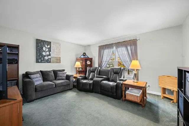 a living room with furniture a flat screen tv and a window