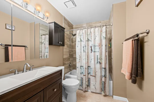 a bathroom with a double vanity sink toilet and shower