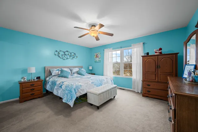 a spacious bedroom with a bed and a chandelier