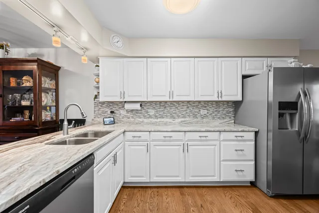a kitchen with granite countertop a sink stove and refrigerator