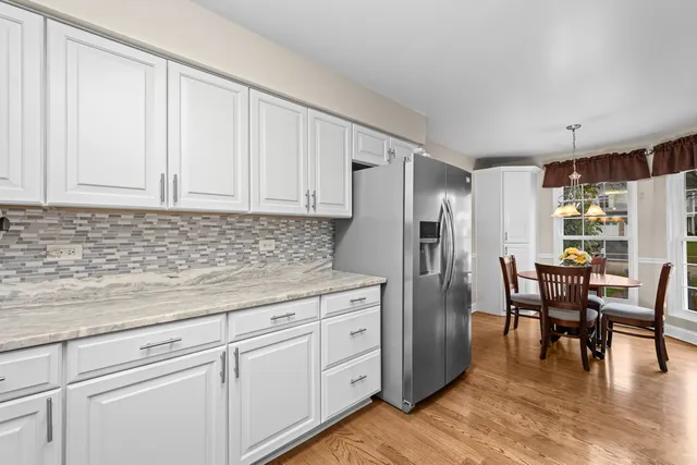 a kitchen with white cabinets and stainless steel appliances