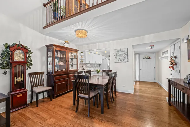 a view of a dining room and livingroom with furniture wooden floor a rug and a painting