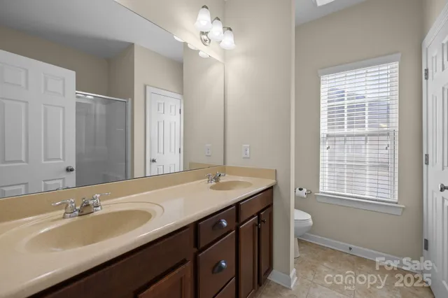 a bathroom with a sink double vanity granite and a mirror