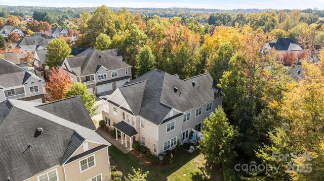 an aerial view of residential houses with outdoor space and trees