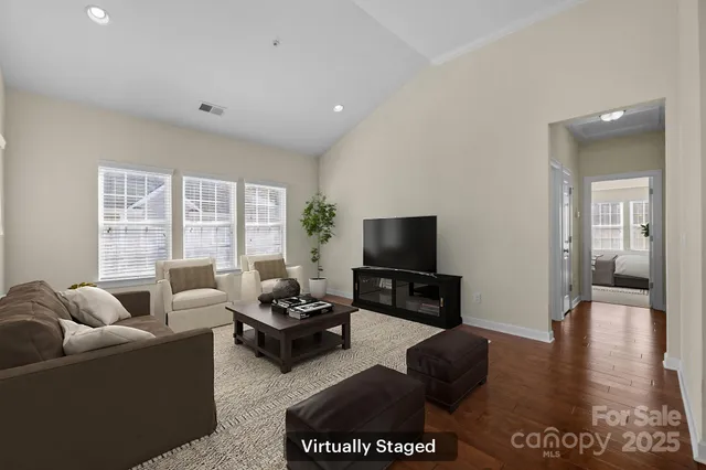 a living room with furniture a flat screen tv and a large window