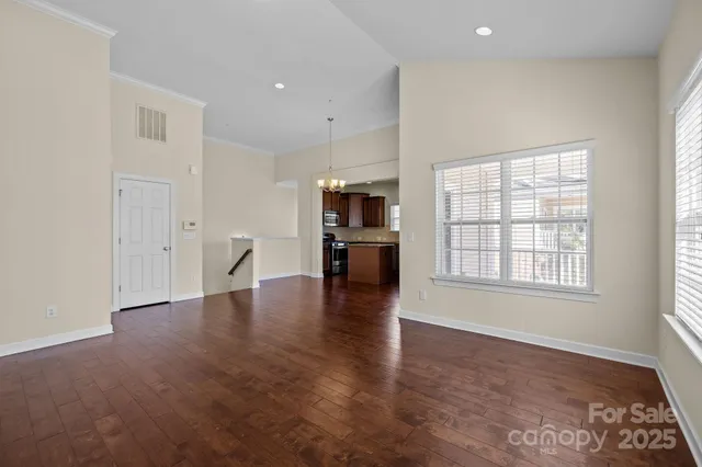 wooden floor in an empty room with a kitchen