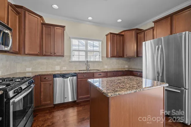 a kitchen with stainless steel appliances granite countertop a refrigerator stove and sink