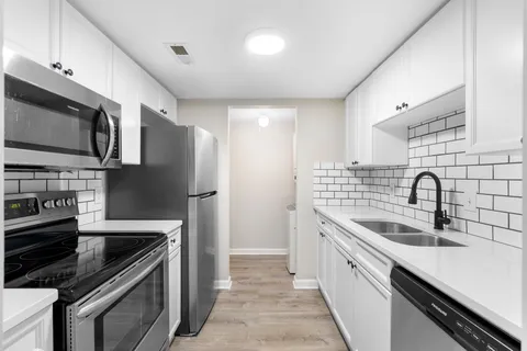 a kitchen with stainless steel appliances a sink stove and refrigerator