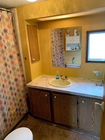 557 Southwest Cutoff, Unit 110 Worcester, MA 01607 - Photo 7 of 8 a bathroom with a sink and a mirror