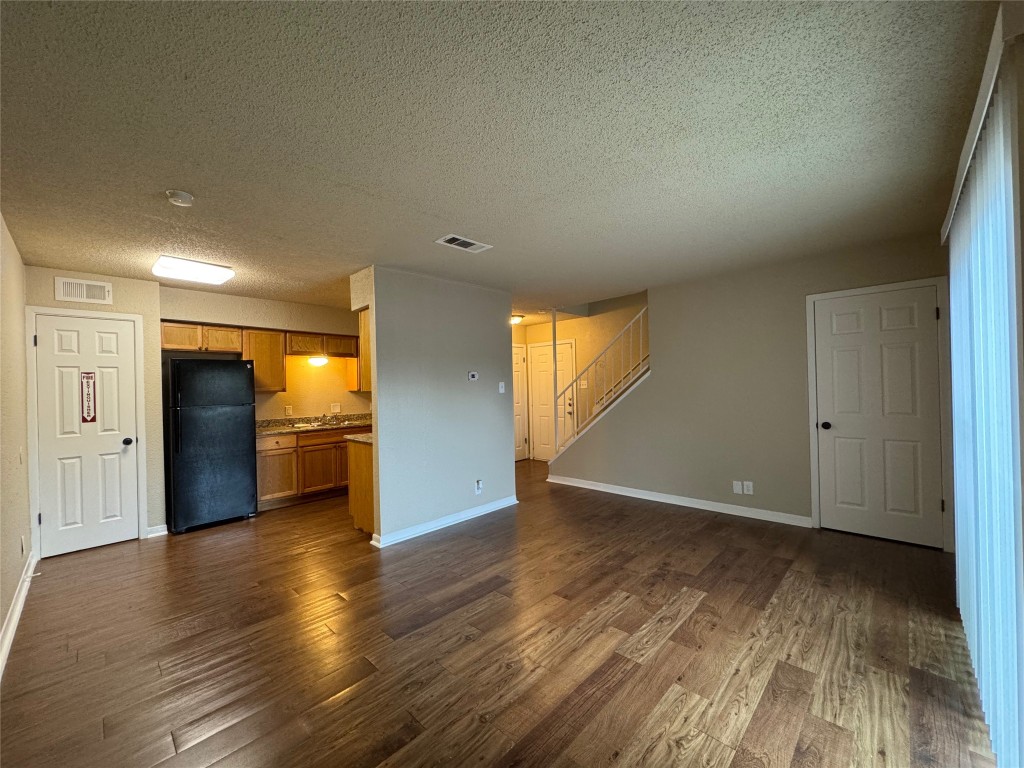 5006 West Wind Trail, Unit 101 Austin, TX 78745 - Photo 3 of 18 a view of empty room with wooden floor and windows