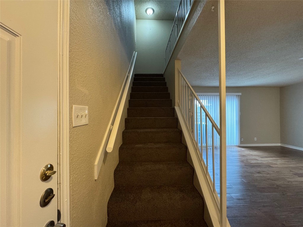 5006 West Wind Trail, Unit 101 Austin, TX 78745 - Photo 10 of 18 a view of staircase with wooden floor and white walls