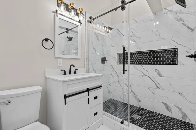 a bathroom with a sink toilet and shower