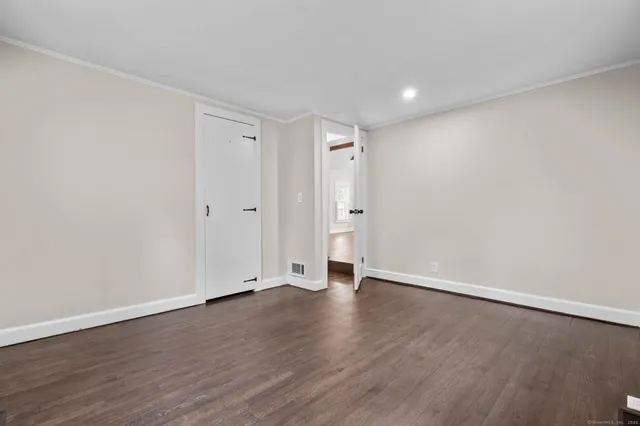 a view of an empty room with wooden floor