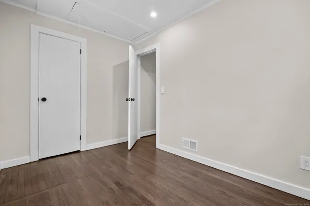 a view of an empty room with wooden floor