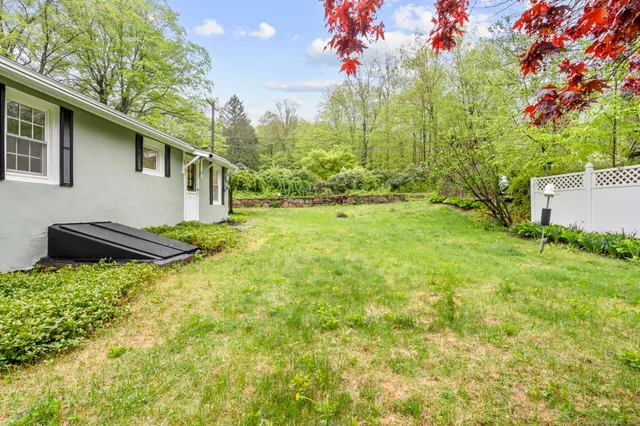 a view of yard in front of house with trees all around
