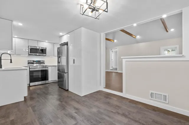 a kitchen with kitchen island a refrigerator cabinets and wooden floor