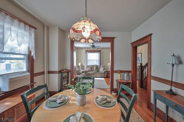 a view of a dining room with furniture a chandelier and wooden floor