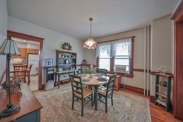 a dining room with furniture window and wooden floor