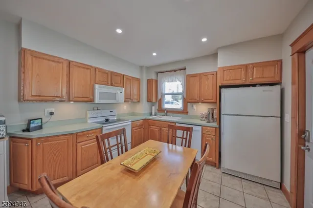 a kitchen with stainless steel appliances granite countertop a refrigerator a sink dishwasher a stove and white countertops with cabinets