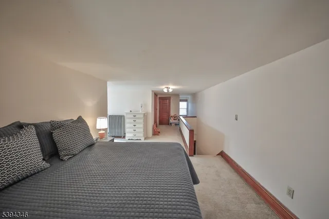 a bedroom with a bed a mirror on dresser and a couch