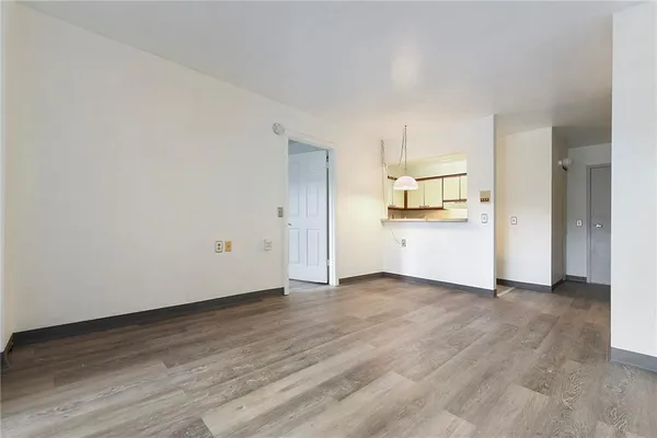 a view of a kitchen with wooden floor and electronic appliances