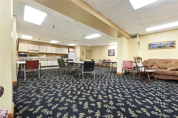 a living room with lots of chairs and a view of dining table