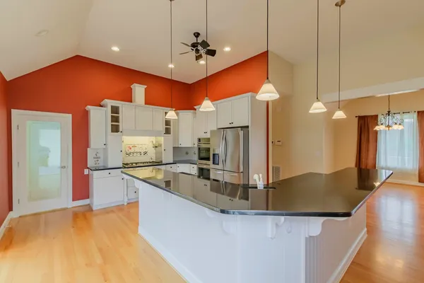 a kitchen with granite countertop white cabinets and white appliances