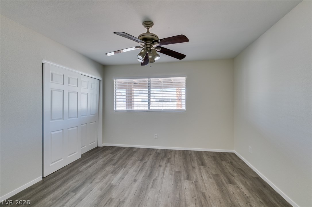 2028 Rustler Ridge Avenue North Las Vegas, NV 89031 - Photo 30 of 40 A well-lit bedroom with modern wood flooring and a refreshing ceiling fan.