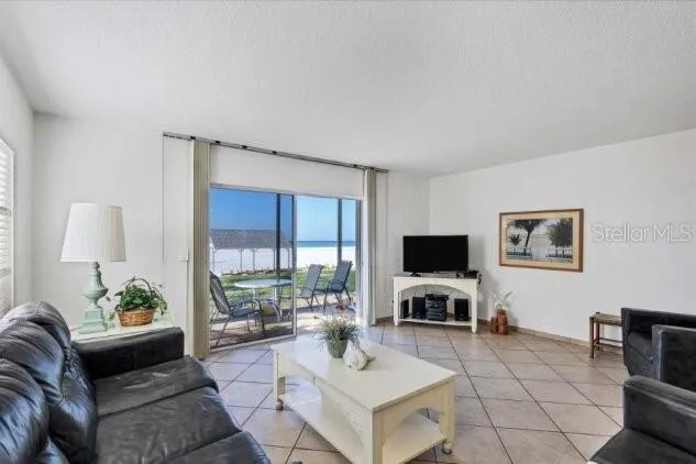 a living room with furniture a flat screen tv and a window