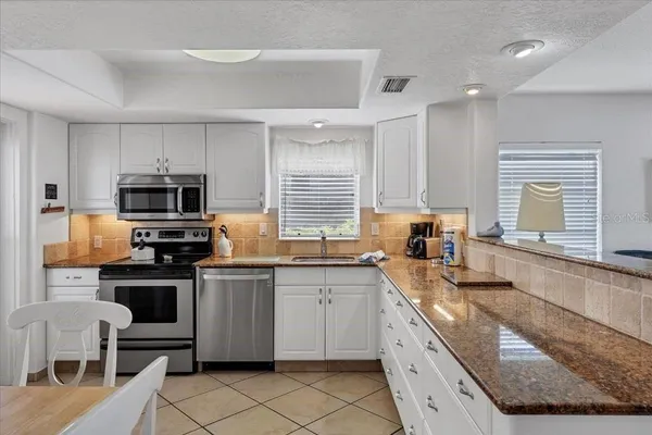 a kitchen with granite countertop a sink and appliances