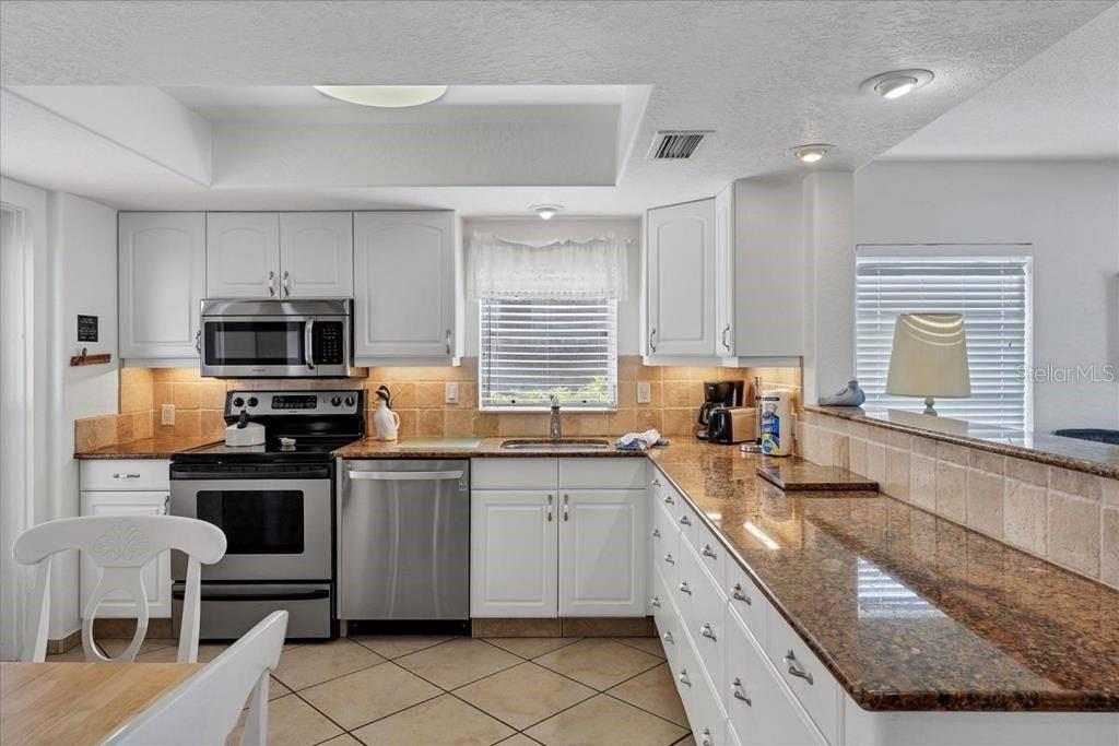 6154 Midnight Pass Road, Unit 101 Sarasota, FL 34242 - Photo 3 of 10 a kitchen with granite countertop a sink and appliances