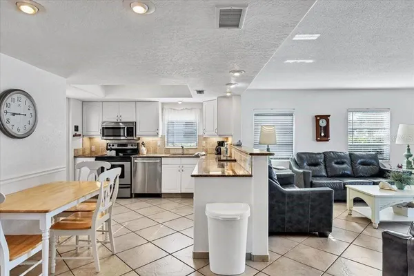 a living room with furniture a kitchen view and appliances