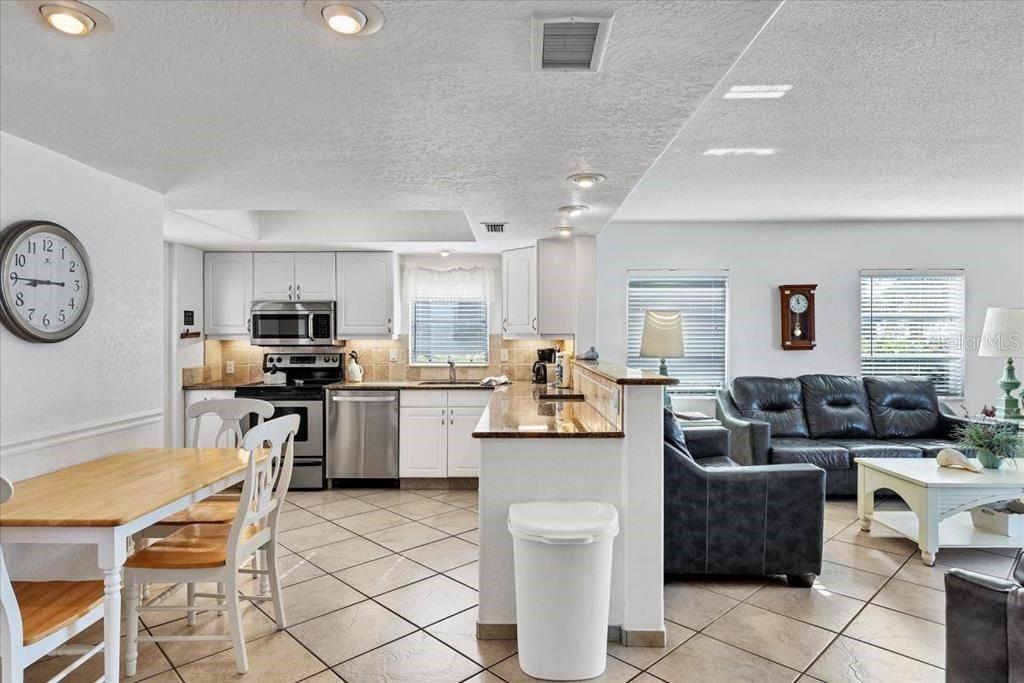 6154 Midnight Pass Road, Unit 101 Sarasota, FL 34242 - Photo 4 of 10 a living room with furniture a kitchen view and appliances