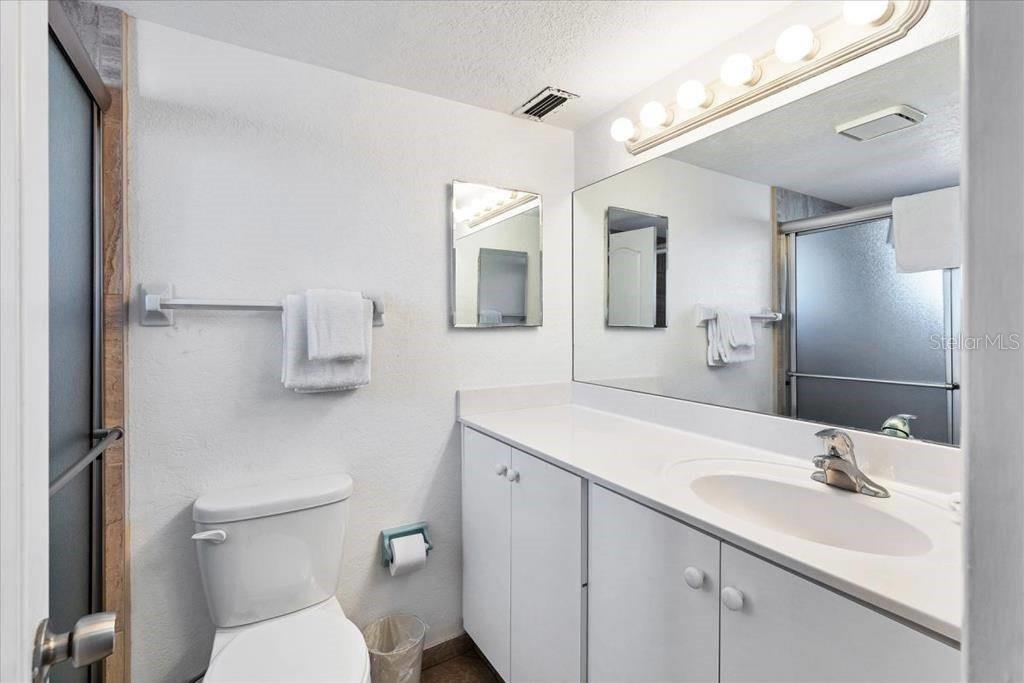 6154 Midnight Pass Road, Unit 101 Sarasota, FL 34242 - Photo 7 of 10 a bathroom with a toilet a sink and mirror
