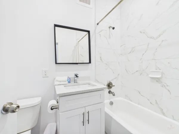 a bathroom with a sink mirror vanity and toilet