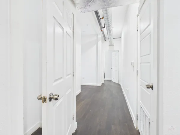 a view of a hallway with wooden floor and staircase