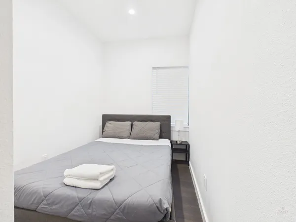 a bedroom with a bed and a night stand