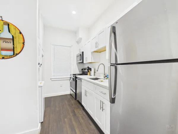 a kitchen with white cabinets and refrigerator