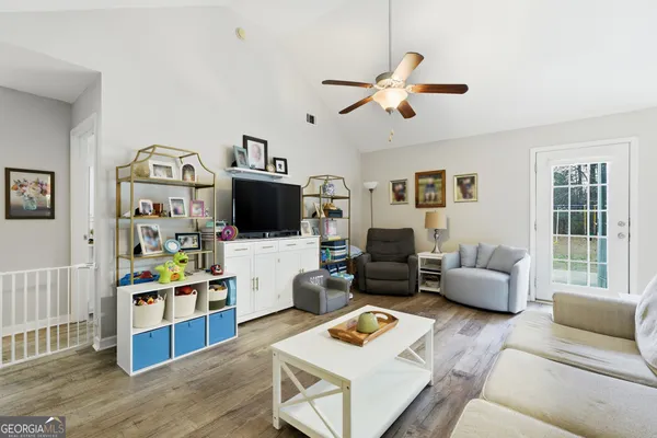 a living room with furniture flat screen tv and a window