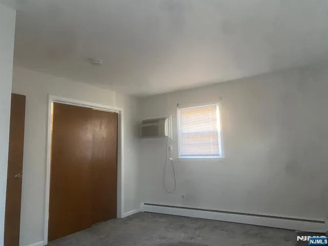 an empty room with windows and closet