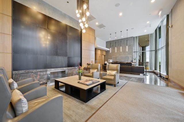 450 East Waterside Drive, Unit 2902 Chicago, IL 60601 - Photo 29 of 44 a living room with couches a fireplace and kitchen view with wooden floor