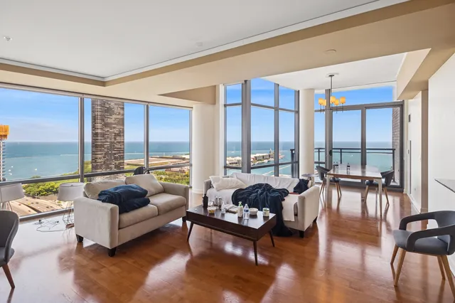 a living room with furniture and floor to ceiling windows
