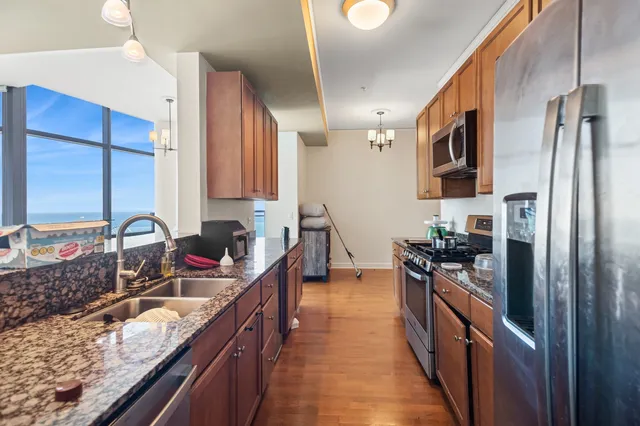 a kitchen with stainless steel appliances granite countertop a sink stove and refrigerator