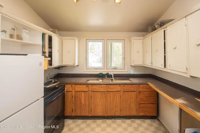 a view of a kitchen with a sink and refrigerator