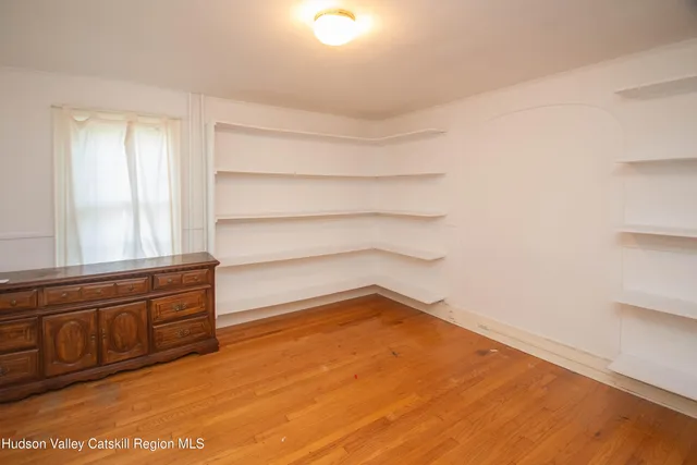 a room with a wooden floor and a window