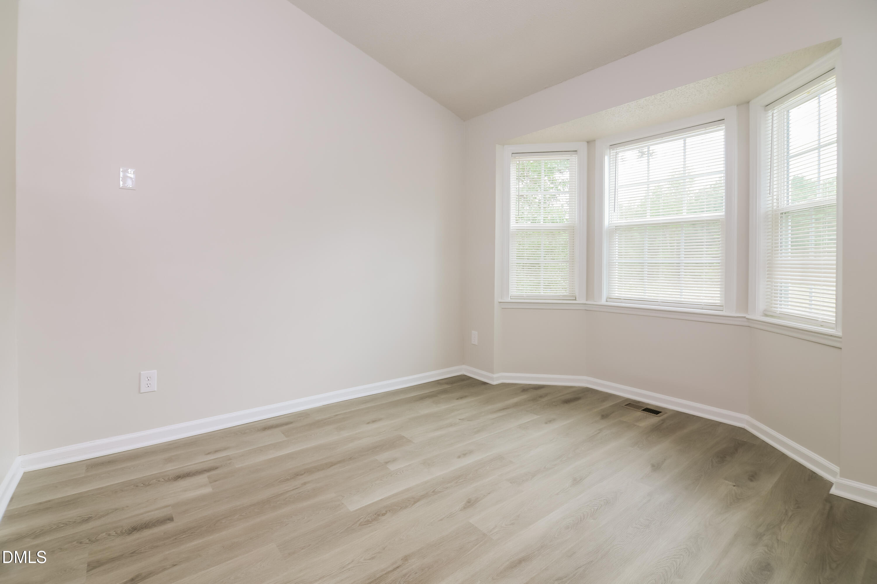 5201 Pronghorn Lane Raleigh, NC 27610 - Photo 4 of 16 an empty room with wooden floor and windows