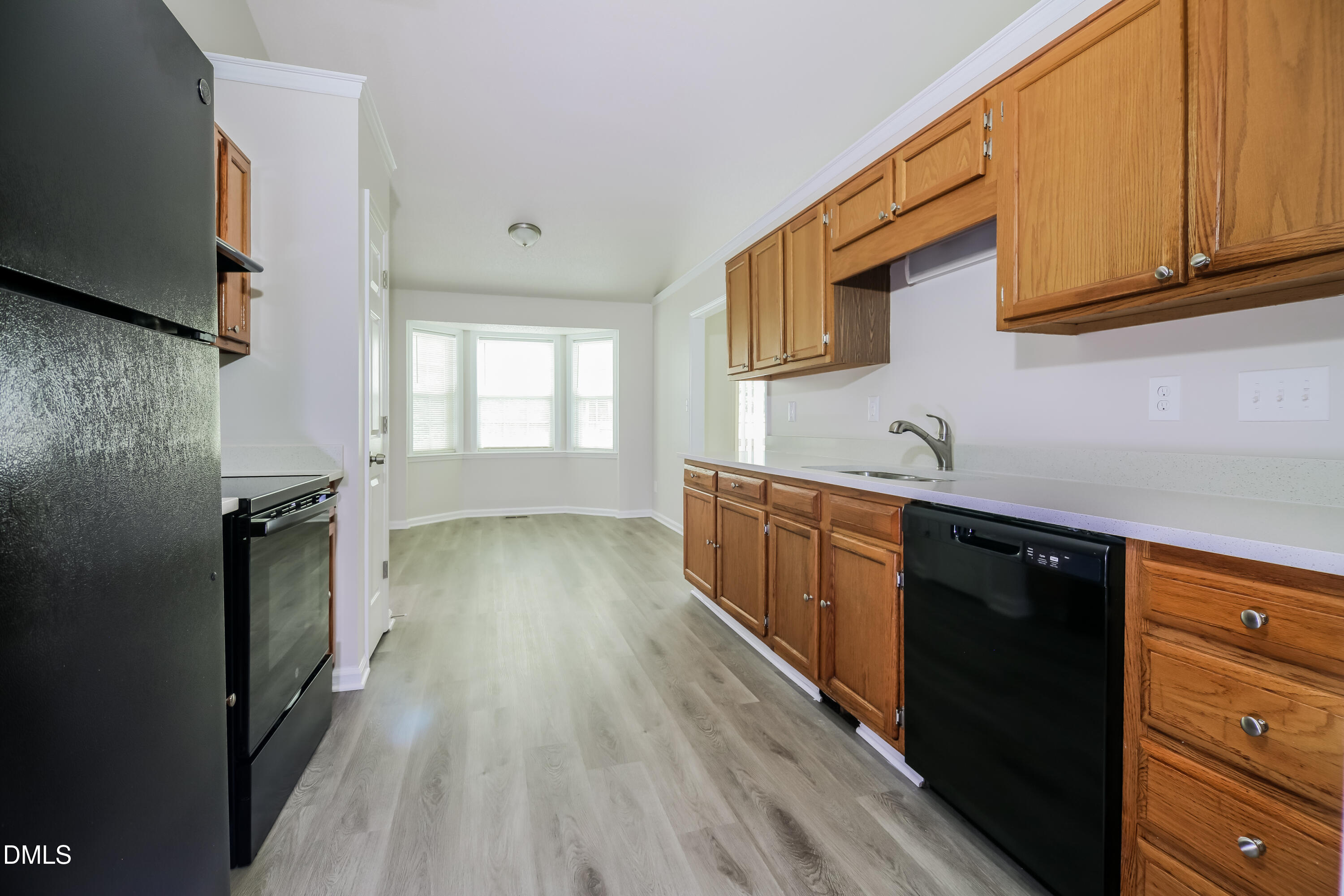 5201 Pronghorn Lane Raleigh, NC 27610 - Photo 7 of 16 a kitchen with stainless steel appliances granite countertop a refrigerator a sink dishwasher a stove and white countertops with wooden floor