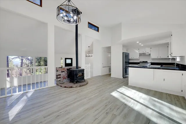 a kitchen with stainless steel appliances granite countertop a stove top oven a sink dishwasher and a refrigerator with wooden floor