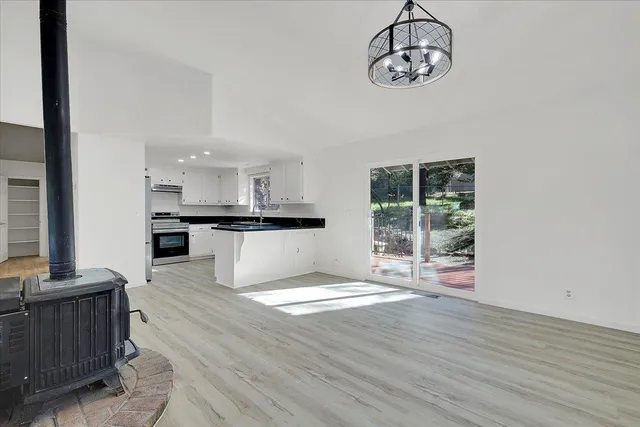 a view of kitchen with granite countertop microwave and stove top oven